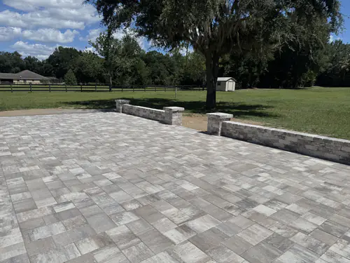 Seat walls and pillars along the edge of the backyard patio with pasture views