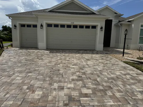 Full width tan, grey and rose paver driveway in front of a double garage and a single garage in The Villages
