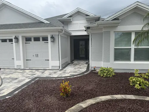 Bordered entry walk curving past red lava rock beds to the front door