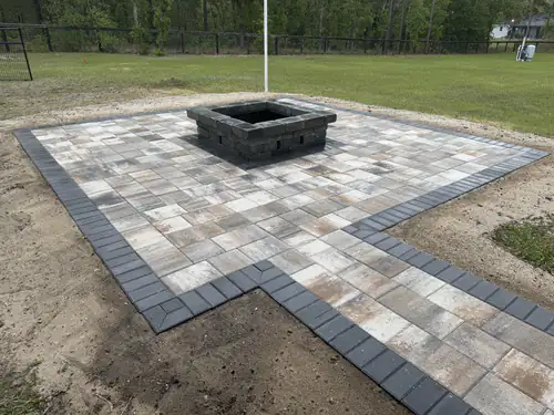 Finished Ocala fire pit pad with an L shaped extension and dark paver border