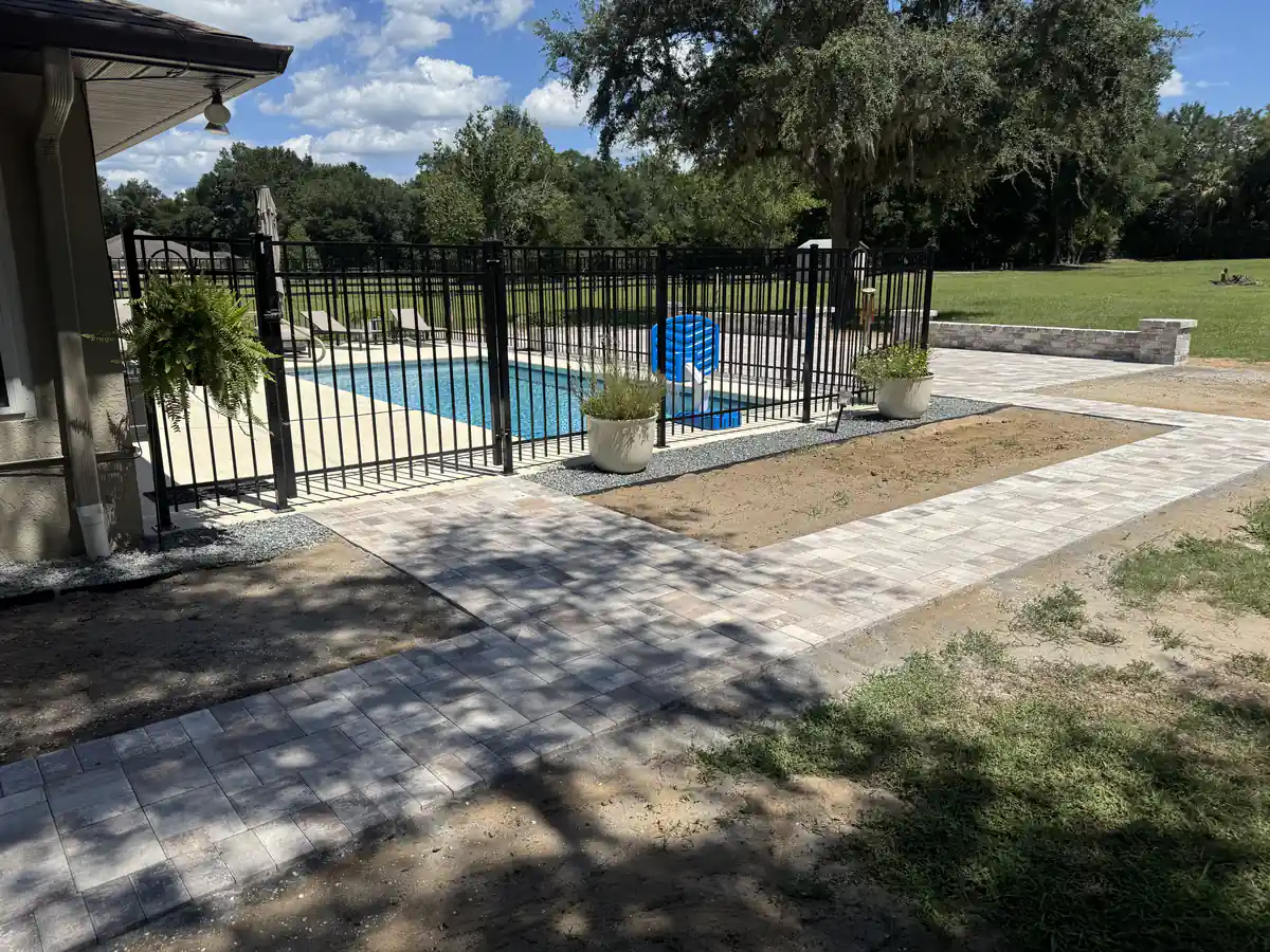 Paver walkway running from the house along the pool fence toward the backyard patio in Ocala